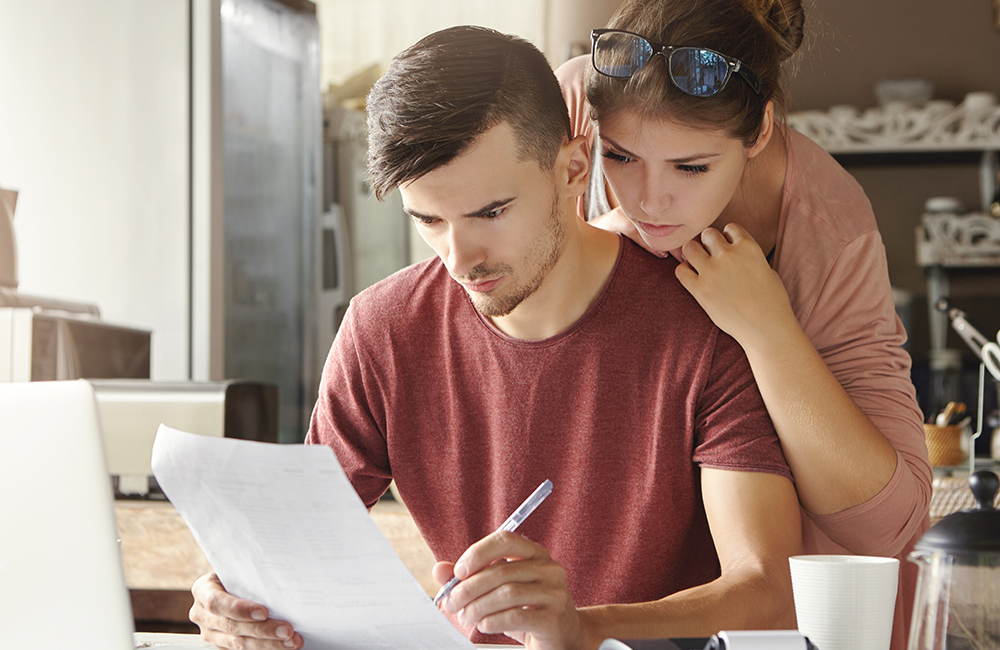 Couple looking stressed while reviewing retirement plan documents